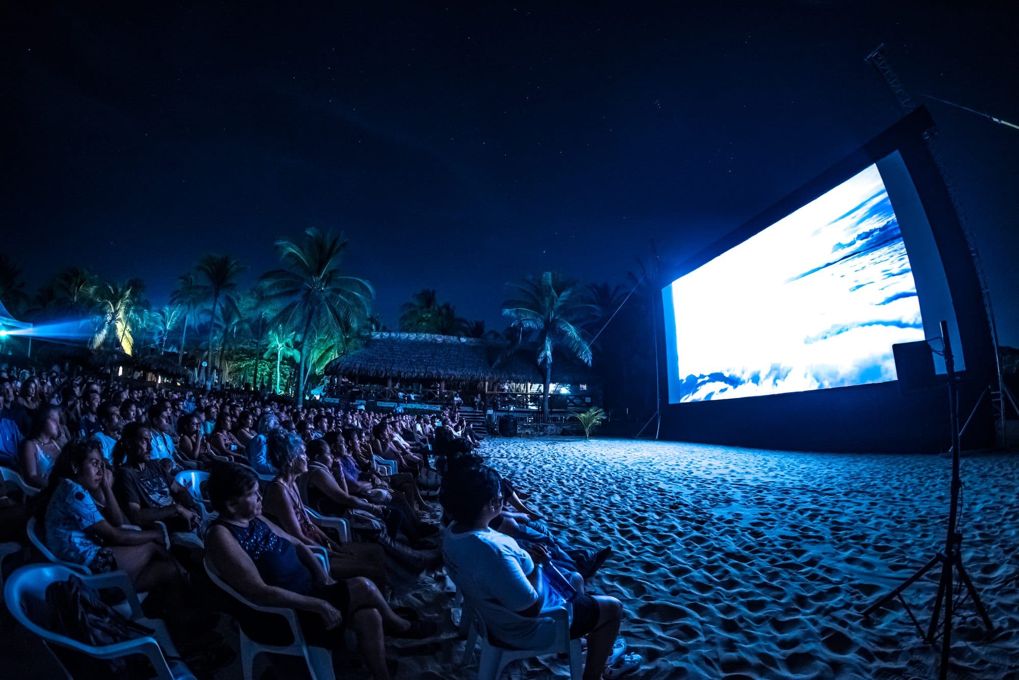 Función nocturna en la playa: el público en la arena frente a la pantalla, Puerto Escondido