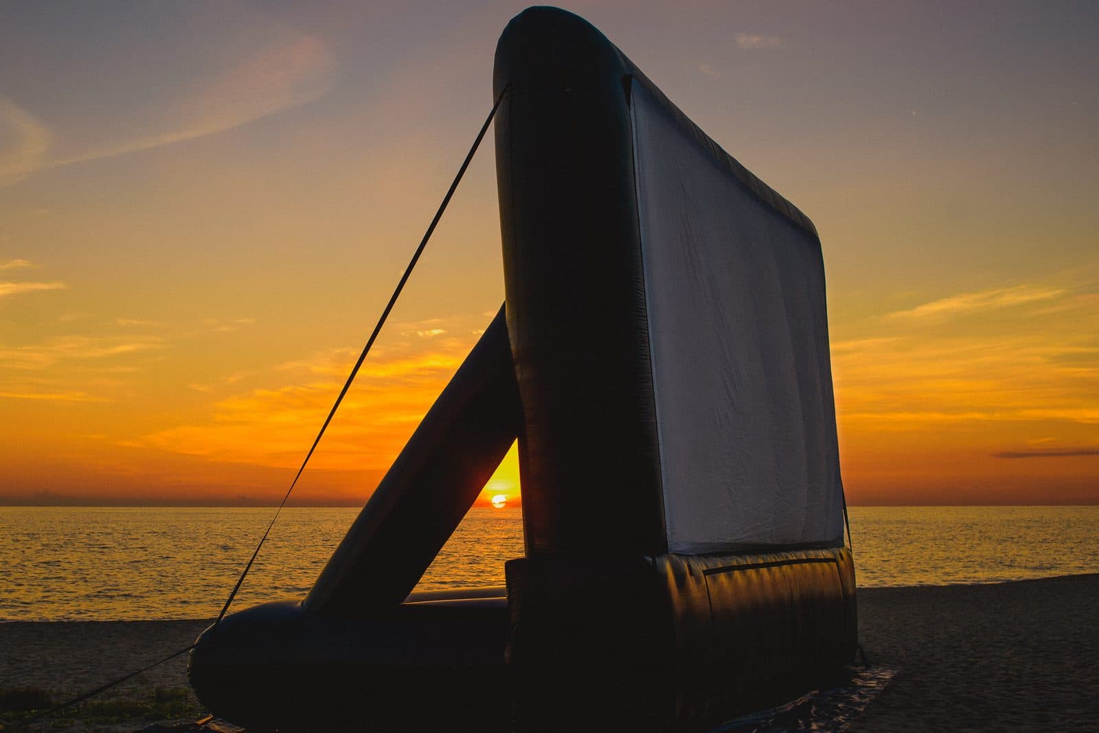 La pantalla inflable contra el atardecer en la playa